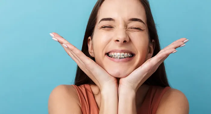 Mulher sorrindo com aparelho fixo nos dentes