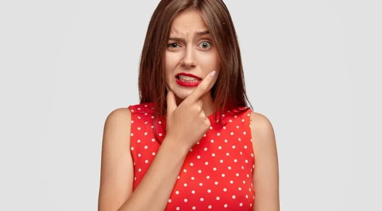 Mulher pensativa com a mão no queixo