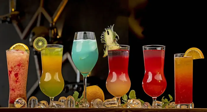 Taças de drinques coloridos com frutas