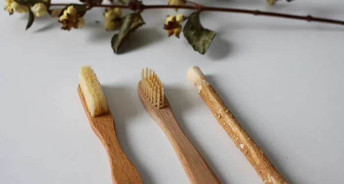 Três escovas de dente de bambu com cerdas naturais lado a lado