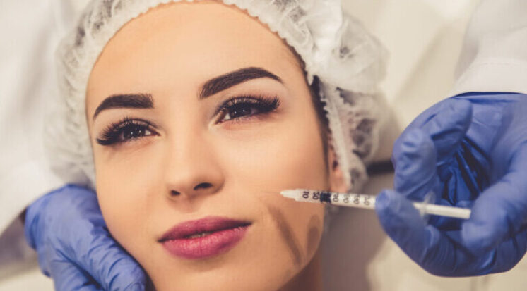 Beautiful young woman is getting an injection in face.