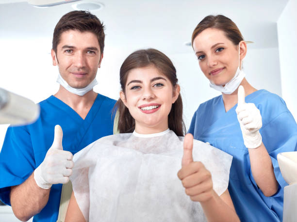 Dentists and patient making sign to confirm.